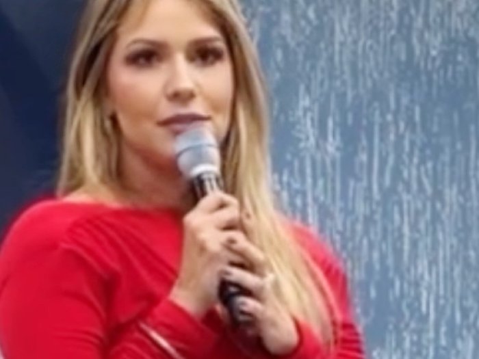 Raquel Cantarelli falando ao microfone num evento